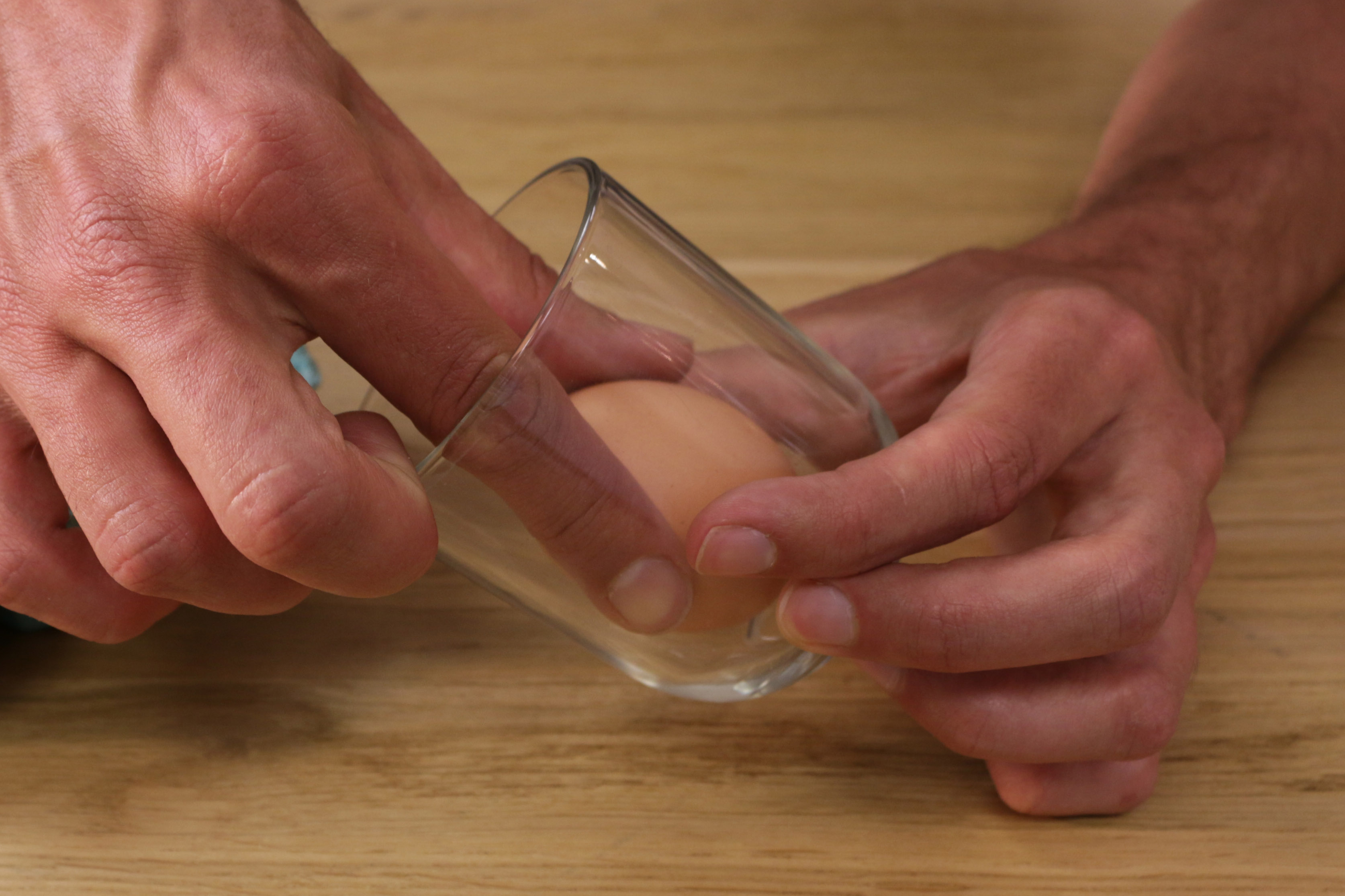 a. Gib das Ei vorsichtig (ohne es zu zerbrechen) in ein Glas.