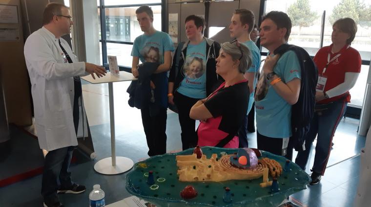 Person in lab coat talking to other people