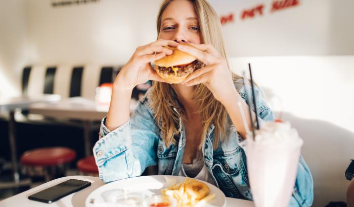 Frau isst Fast Food