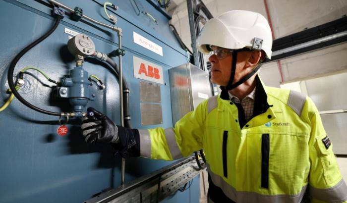 Guy Nicholson, responsable des solutions réseau neutres en carbone chez Statkraft, se tient près d'un volant d'inertie, le 7 août 2025 à Liverpool