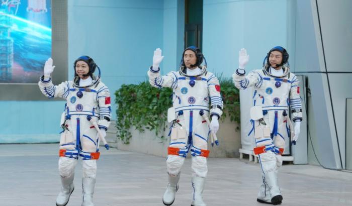 (g-d) Les astronautes de la mission spatiale chinoise Shenzhou-23 Li Jiaying, Zhu Yangzhu et Zhang Zhiyuan saluent la foule lors d'une cérémonie de départ au Centre de lancement de satellites de Jiuquan, dans le désert de Gobi, au nord-ouest de la Chine, le 24 mai 2025