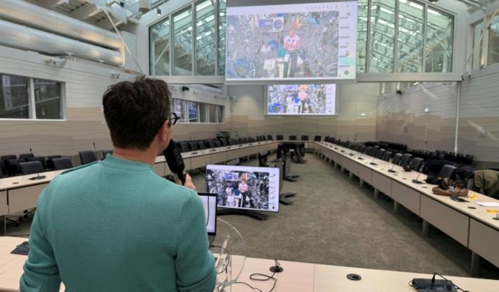 Le journaliste de l'AFP Frédéric Bourigault (à gauche) interroge l'astronaute de l'ESA Sophie Adenot (sur les écrans) qui se trouve à bord de la Station spatiale internationale (ISS), au siège de l'Agence spatiale européenne (ESA) à Paris, le 26 février 2026