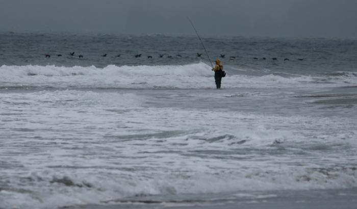 Un pêcheur au bord de l'océan Pacifique, le 30 juillet 2025 à San Francisco (Californie)
