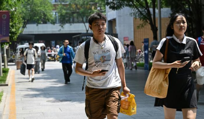 Un étudiant chinois devant l'Université des études internationales de Pékin, portant un t-shirt sur le marathon de New York, le 29 mai 2025