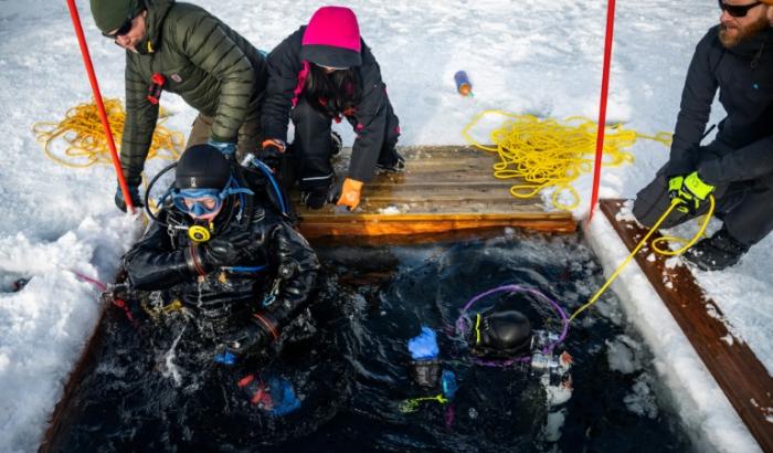 Un plongeur est extrait des eaux glacées lors d'un stage scientifique de plongée polaire, le 14 mars 2026 dans le lac de Kilpisjärvi, à l'extrême nord-ouest de la Finlande