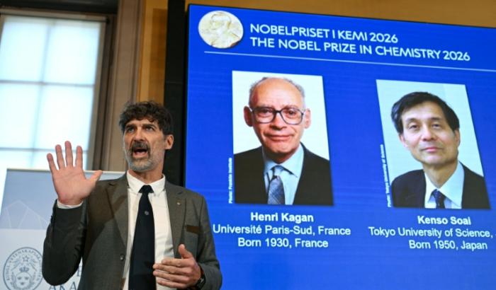 Heiner Linke (g), président du comité Nobel de chimie, à côté d'un écran affichant les portraits des lauréats, le Français Henri Kagan et le Japonais Kenso Soai à l'Académie royale des sciences de Suède, à Stockholm, le 7 octobre 2026