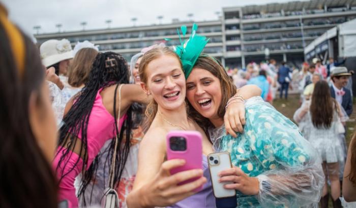 Des amies sourient pour un selfie lors de la 151e édition du Kentucky Derby à Louisville (Kentucky), aux Etats-Unis, le 3 mai 2025