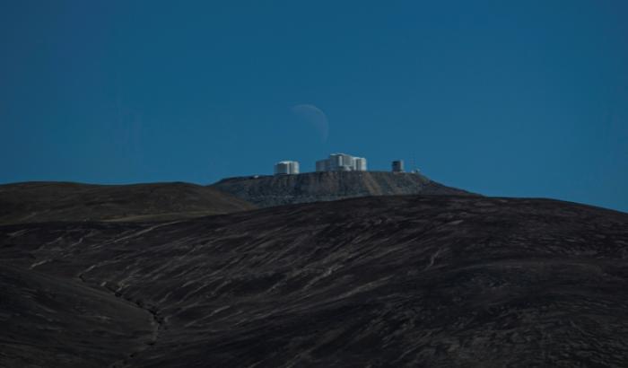 Le dernier quartier de lune se couche derrière la plateforme du Very Large Telescope (VLT), à l'Observatoire européen austral (ESO) de Paranal dans le désert d'Atacama, à environ 1.150 km au nord de Santiago du Chili, le 21 juin 2022
