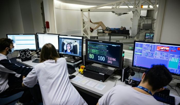 Du personnel médical étudie les données d'un volontaire allongé sur une centrifugeuse lors d'une expérience à la clinique de Medes, filiale santé du Centre national d'études spatiales (CNES), à Toulouse, le 23 mai 2023