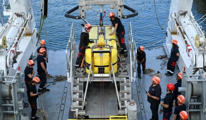 Des techniciens effectuent un test de lancement du robot sous-marin Ulyx à bord du navire scientifique Atalante amarré au port de Brest avant son départ, le 15 juin 2025 dans le Finistère