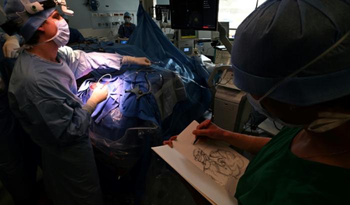 Une étudiante de l'Ecole Supérieure d'Art et de Design (Esad) dessine pendant une opération du cerveau sur un patient éveillé atteint d'une tumeur cérébrale, dans le cadre d'un programme interdisciplinaire franco-allemand en neurochirurgie, le 5 mars 2025 au CHU de Reims