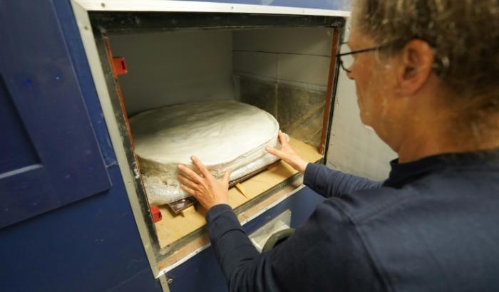 La conservatrice Helle Strehle place un cercueil préservé de l'ère viking découvert à Lisbjerg dans un appareil à rayons X dans les laboratoires du musée Moesgaard à Aarhus, au Danemark, le 13 juin 2025