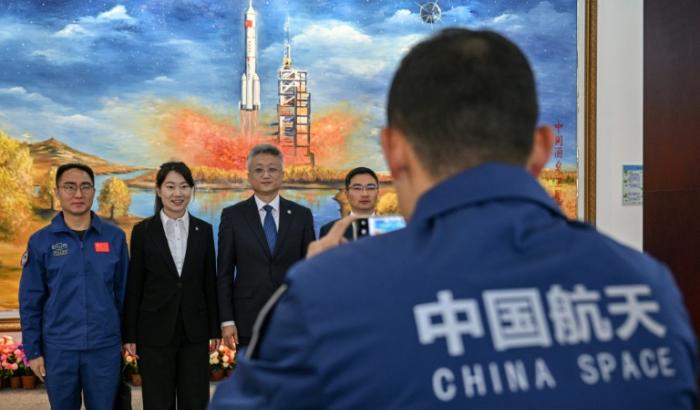 Zhang Jingbo (C), porte-parole du Programme spatial habité de la Chine, avec des membres du personnel après une conférence de presse sur la mission spatiale habitée Shenzhou-21, un jour avant le lancement de la mission au Centre de lancement de satellites de Jiuquan à Jiuquan, dans la province de Gansu, le 30 octobre 2025