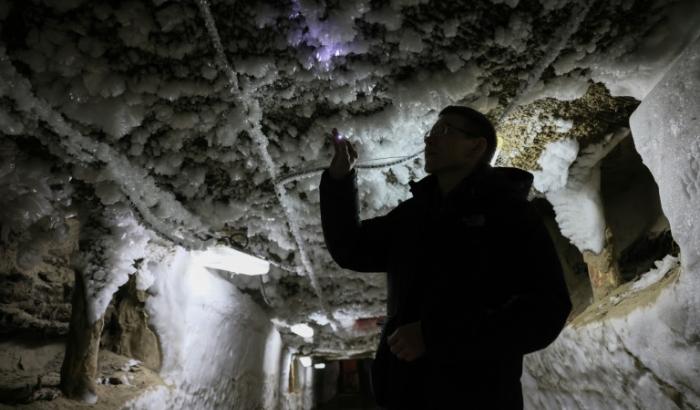 Un scientifique examine les formes de glace qui sortent du pergélisol dans un tunnel souterrain à l'Institut du pergélisol à Iakuutsk, le 28 mars 2025 en Sibérie orientale