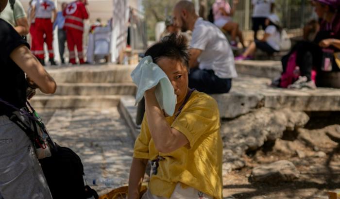 Une touriste s'essuie le visage lors d'une vague de chaleur à Athènes, le 23 juillet 2025 en Grèce
