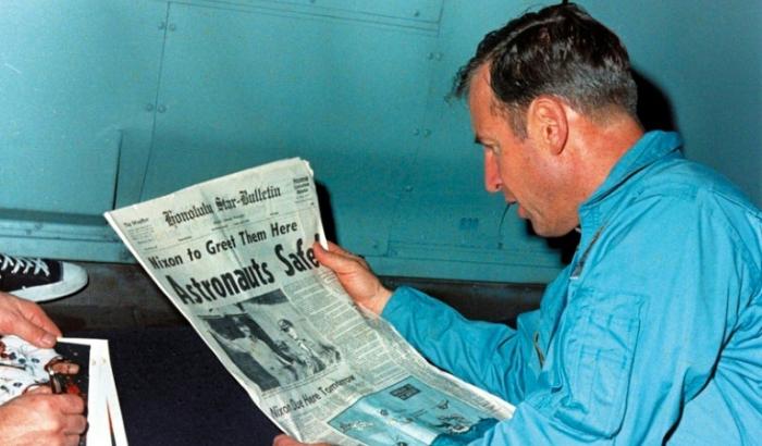 Jim Lovell en train de lire le journal évoquant le sauvetage périlleux d'Apollo 13 le 17 avril 1970, à bord de l'USS Iwo