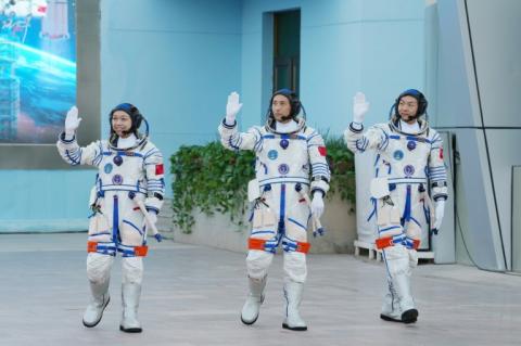 (g-d) Les astronautes de la mission spatiale chinoise Shenzhou-23 Li Jiaying, Zhu Yangzhu et Zhang Zhiyuan saluent la foule lors d'une cérémonie de départ au Centre de lancement de satellites de Jiuquan, dans le désert de Gobi, au nord-ouest de la Chine, le 24 mai 2025