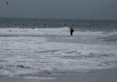 Un pêcheur au bord de l'océan Pacifique, le 30 juillet 2025 à San Francisco (Californie)