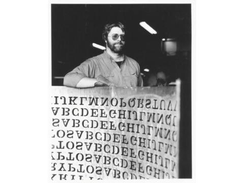 Cette photo de 1990, fournie par Jim Sanborn, montre le sculpteur Jim Sanborn avec un bout de sa sculpture en cuivre "Kryptos", installée au siège de la CIA, en Virginie, aux Etats-Unis