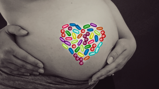 Schwangere Frau mit Herz aus Bakterien.