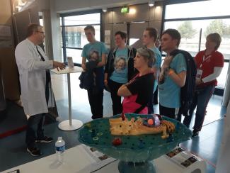 Person in lab coat talking to other people