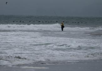 Un pêcheur au bord de l'océan Pacifique, le 30 juillet 2025 à San Francisco (Californie)