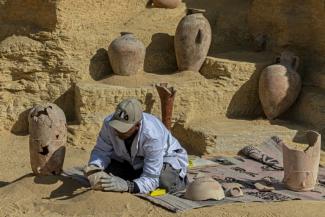 Un archéologue reconstitue des poteries découvertes lors d'une fouille archéologique dans la nécroprole de Saqqara, le 26 janvier 2023 en Egypte