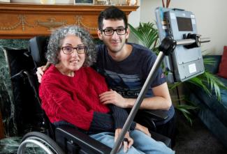 Cette photo fournie par Smartbox Assistive Technology montre Sarah Ezekiel et son fils Eric chez eux à Hendon, au nord de Londres, le 16 août 2025.