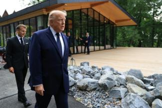 Le président américain Donald Trump (au centre) arrive aux côtés du président français Emmanuel Macron avant la prise d'une photo de groupe lors d'un dîner de gala organisé dans le cadre du G7, à Evian, en Haute-Savoie, le 16 juin 2026