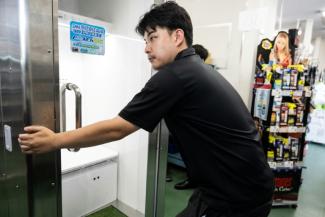 Un employé de Konoe déplace un "réfrigérateur humain", dans l'entrepôt de son entreprise, situé à Higashiosaka, dans la préfecture d'Osaka, le 21 août 2026