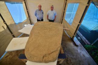 Les archéologues Lino Espinoza (g) et Alberto Vazquez (d) près d'une stèle de 2,5 tonnes découverte sur un site archéologique à Coatepec, au Mexique, le 18 juin 2026