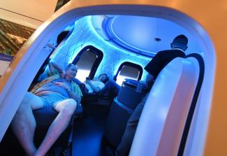 Des visiteurs à l'intérieur d'une capsule de démonstration de Blue Origin, lors du salon Re:Mars organisé par Amazon, à Las Vegas dans le Nevada